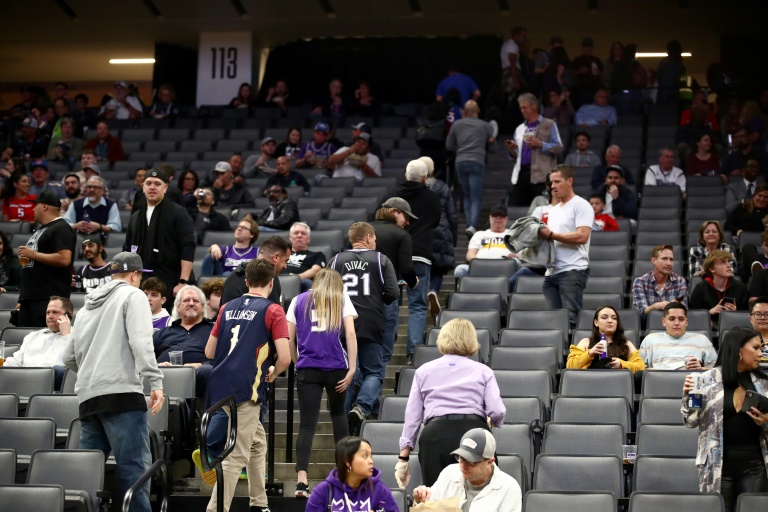 Aficionados abandonan la cancha de los Sacramento Kings tras la suspensión del juego ante Pelicans.