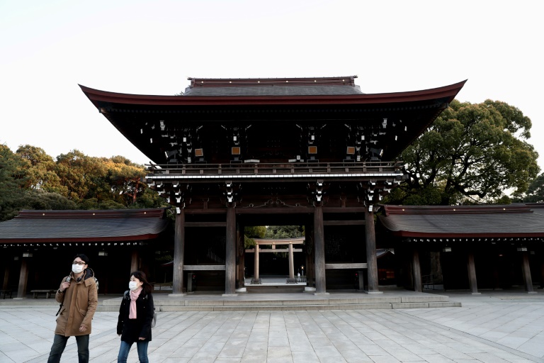 Una pareja con mascarillas protectoras visita un casi vacío santuario Meiji, el 7 de abril de 2020 en Tokio.