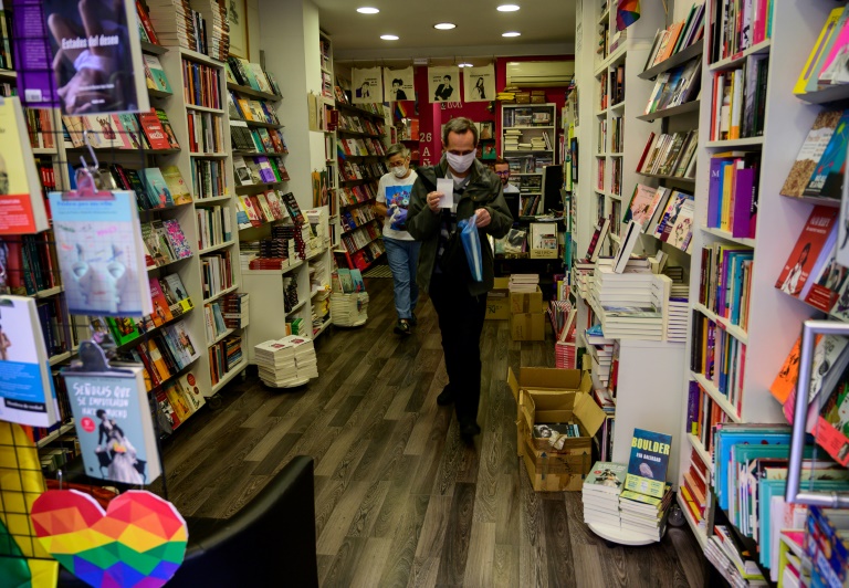 Un cliente con mascarilla sale de una librería de Madrid con un libro en el primer día de reapertura de comercios tras las restricciones impuestas por el coronavirus, el 4 de mayo de 2020 en la capital de España.