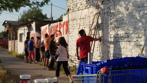 Vecinas y vecinos de la población La Victoria se reunieron este lunes para pintar un mural en recuerdo de Aníbal Villarroel (26), quien murió asesinado en el lugar. Foto: Víctor Pino.