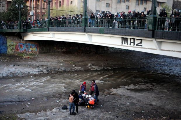 El viernes 2 de octubre, mientras se realizaban manifestaciones en el sector de Plaza Italia, un joven de 16 años fue empujado por un carabinero desde el puente Pío Nono al río Mapocho. Foto: Agencia UNO.