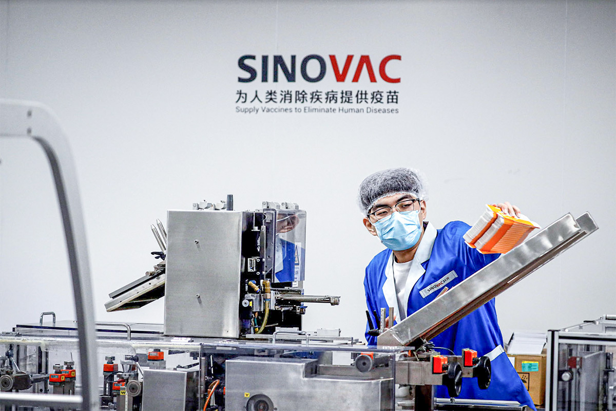 FILE PHOTO: A man works in the packaging facility of Chinese vaccine maker Sinovac Biotech, developing an experimental coronavirus disease (COVID-19) vaccine, during a government-organized media tour in Beijing, China, September 24, 2020. REUTERS/Thomas Peter/File Photo