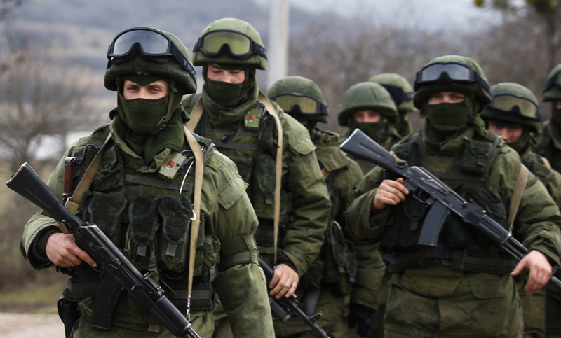 Armed men, believed to be Russian servicemen, march outside an Ukrainian military base in the village of Perevalnoye near the Crimean city of Simferopol March 9, 2014. Shots were fired in Crimea to warn off an unarmed international team of monitors and at a Ukrainian observation plane, as the standoff between occupying Russian forces and besieged Ukrainian troops intensified. REUTERS/Thomas Peter   (UKRAINE - Tags: POLITICS MILITARY)