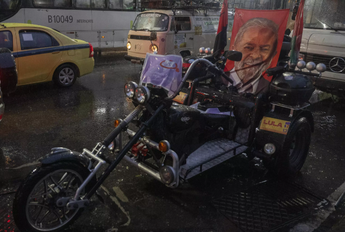 Una moto adornada con un cartel con el rostro del expresidente de Brasil y candidato Luiz Inácio Lula da Silva en un mitin de campaña en Rio de Janeiro el 28 de octubre de 2022 Pablo PORCIUNCULA AFP.