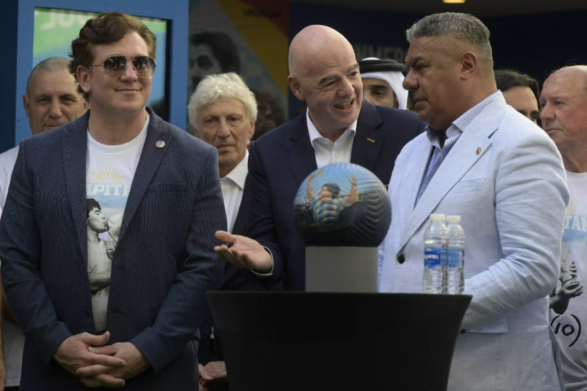 Los presidentes de la FIFA, Gianni Infantino (c); la Conmebol, Alejandro Domínguez (izq.); y la Asociación del Fútbol Argentino, Claudio Tapia, homenajean al fallecido futbolista Diego Maradona el 25 de noviembre de 2022 en Doha Juan Mabromata AFP.