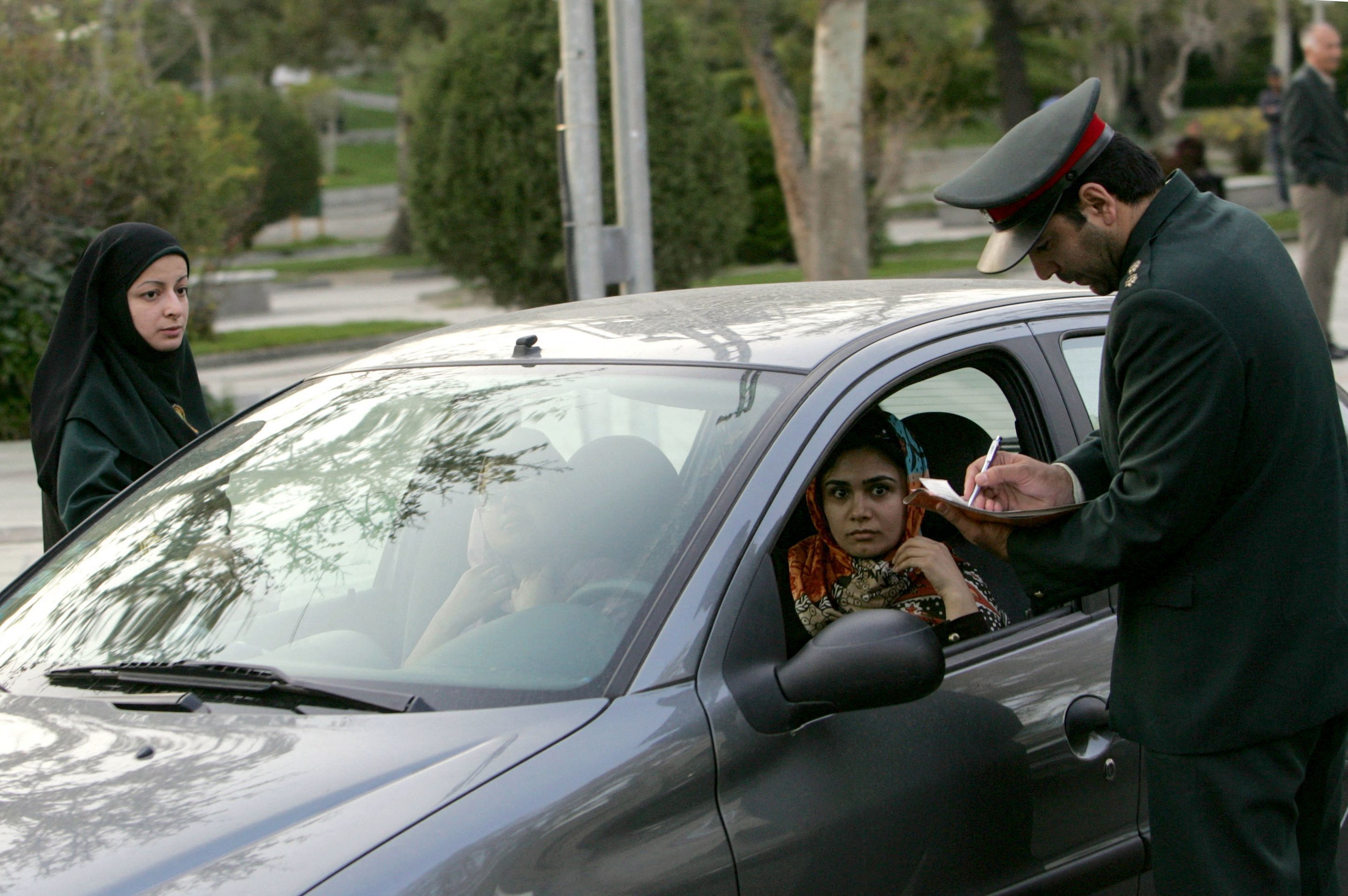 (FILES) In this file photo taken on April 22, 2007, Iranian police officers stop a car during a crackdown to enforce the Islamic dress code in the north of the capital Tehran. - Iran has scrapped its morality police after more than two months of protests triggered by the arrest of Mahsa Amini for allegedly violating the country's strict female dress code, local media said Sunday. (Photo by Behrouz MEHRI / AFP)