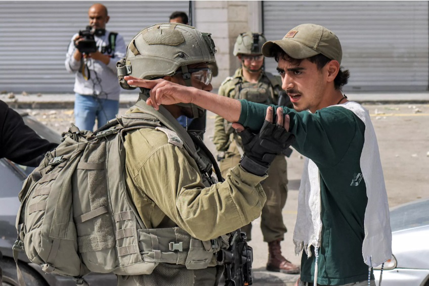 Un soldado israelí discute con un colono en una calle de la localidad palestina de Huwara, el 27 de febrero de 2023 cerca de la ciudad cisjordana de Naplusa © Ronaldo Schmidt / AFP