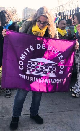 La dirigente Valeria Bustos con la bandera del Comité de Vivienda por un Santiago Multicolor.