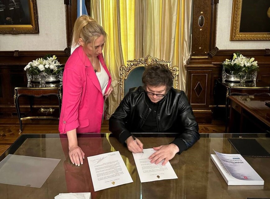 Presidente de Argentina, Javier Milei, firma un documento en su despacho.