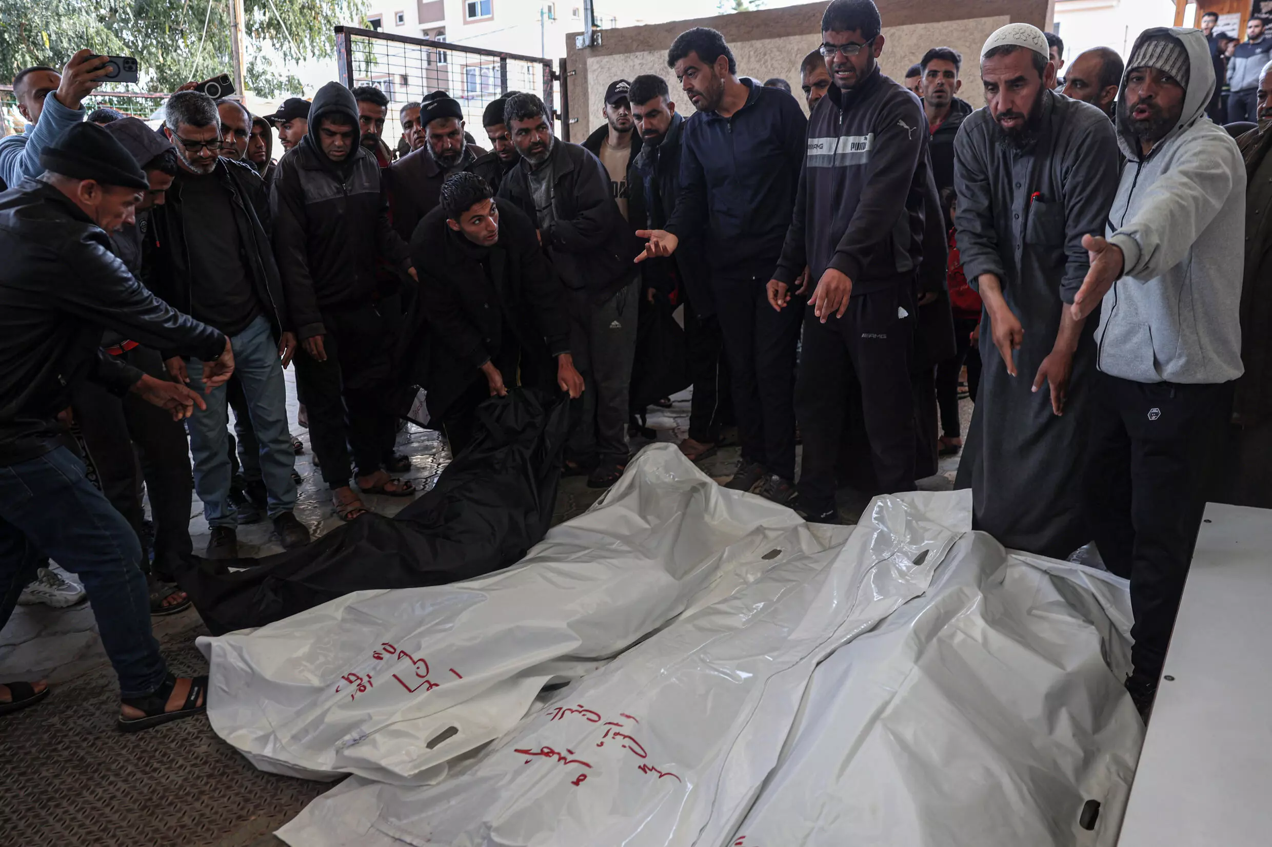 Unos palestinos rodean los cadáveres cubiertos con telas blancas de allegados muertos en un bombardeo israelí, el 23 de marzo de 2024 en la morgue del hospital Europeo de la ciudad de Jan Yunis, al sur de la Franja de Gaza © . / AFP