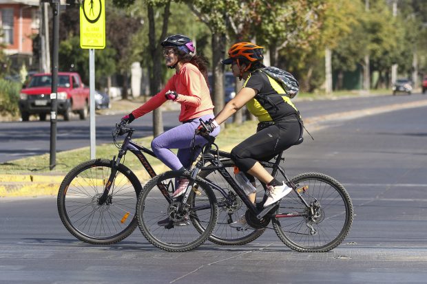 Mujeres andando en bicicleta por la calle, en el marco del día nacional del deporte
