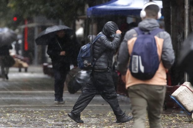 Transeúntes circulan por la Plaza de armas bajo la Lluvia en Santiago