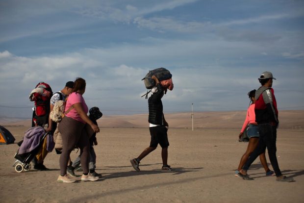 Personas migrantes en el paso fronterizo de Arica