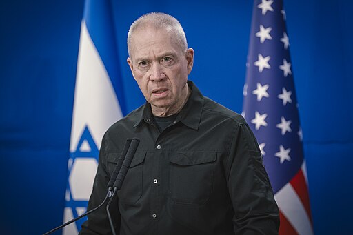 Yoav Gallat con la bandera de Israel y Estado Unidos detrás de él.