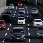 Vista aérea de tráfico denso en una autopista de Santiago de Chile, con varios carriles llenos de autos y SUVs.