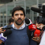 Exdiputado Joaquín Lavín León rodeado de camarógrafos y micrófonos de distintos medios de comunicación.