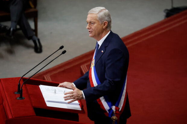 José Antonio Kast entrega discurso vistiendo la banda presidencial desde un podio.