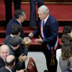El Presidente Kast sonríe y estrecha la mano de Claudio Alvarado en el Congreso Nacional mientras los asistentes a su primera Cuenta Pública aplauden.